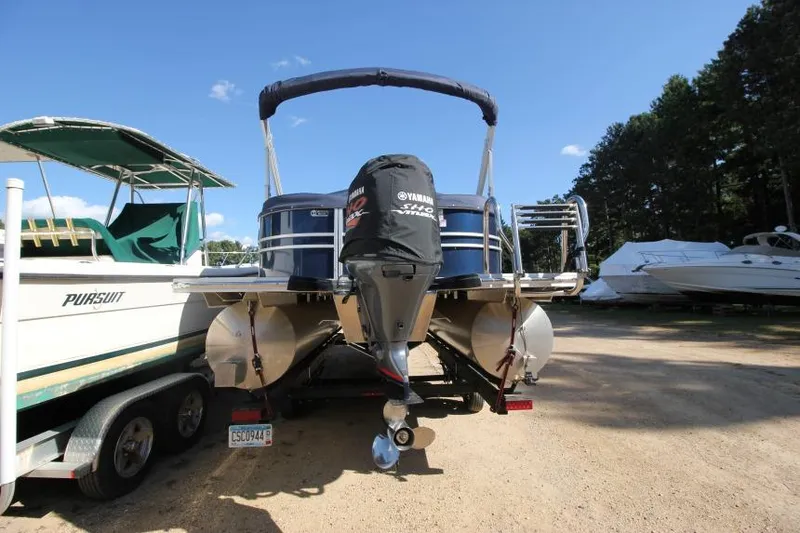 Slide: The Image of 2022 Sylvan L3 LZ pontoon boat with Yamaha outboard motor, parked on a sunny day. - 4
