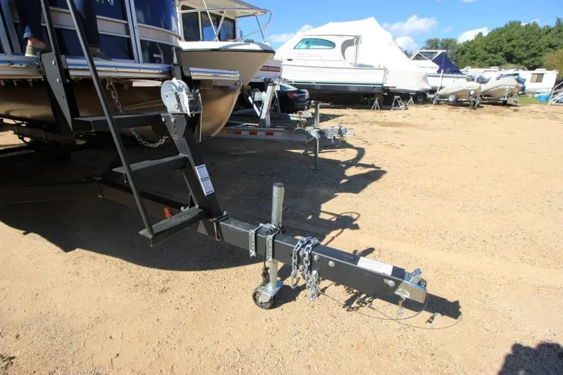 Slide: The Image of 2022 Sylvan L3 LZ boat trailer hitch on sandy ground, surrounded by other boats. - 6
