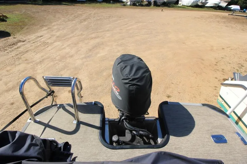 Slide: The Image of 2022 Sylvan L3 LZ boat with covered outboard motor on sandy terrain. - 7