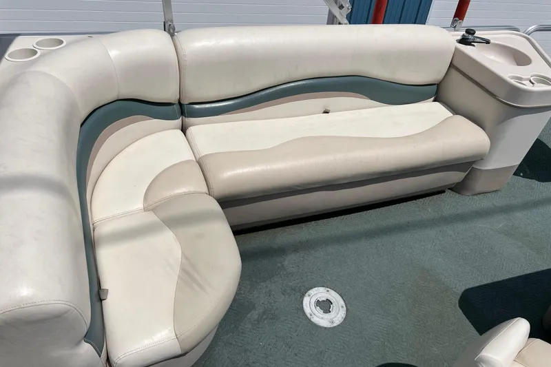 Slide: The Image of 2006 Sun Tracker Party Barge 24 interior with beige and teal seating. - 12