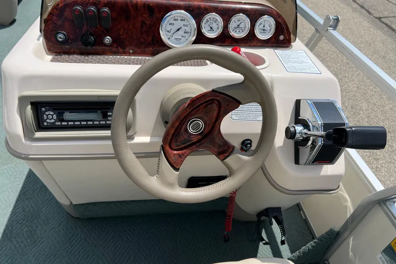 Slide: The Image of 2006 Sun Tracker Party Barge 24 dashboard with steering wheel and control panel. - 21