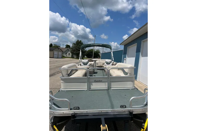 Slide: The Image of 2006 Sun Tracker Party Barge 24 pontoon boat with seating, parked outdoors. - 9