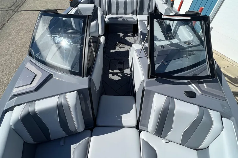 Slide: The Image of 2023 Malibu Wakesetter 22 LSV interior with sleek gray seating and open windshield. - 25