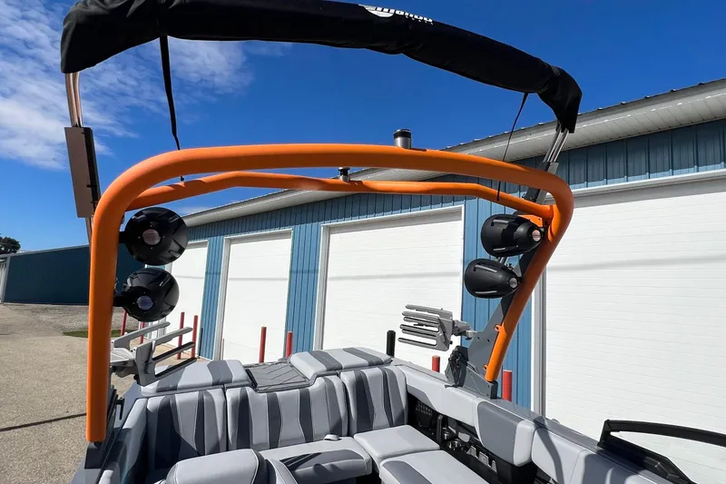 Slide: The Image of 2023 Malibu Wakesetter 22 LSV boat with orange tower and speakers, parked outdoors. - 27
