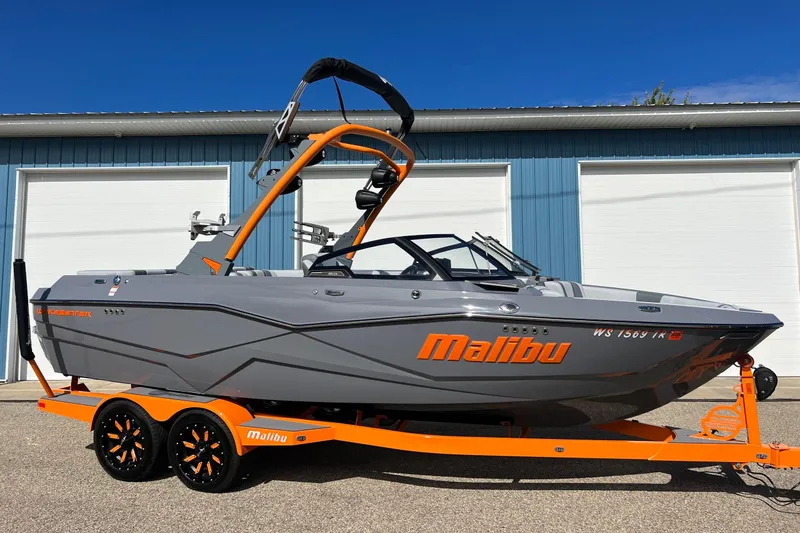 Slide: The Image of 2023 Malibu Wakesetter 22 LSV boat in gray and orange, parked on a trailer. - 3