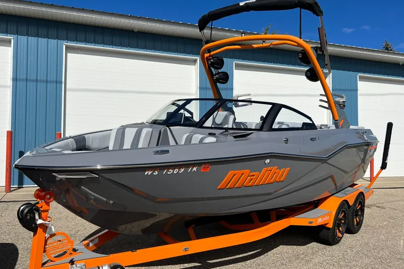 Slide: The Image of 2023 Malibu Wakesetter 22 LSV boat with orange accents on a trailer. - 32