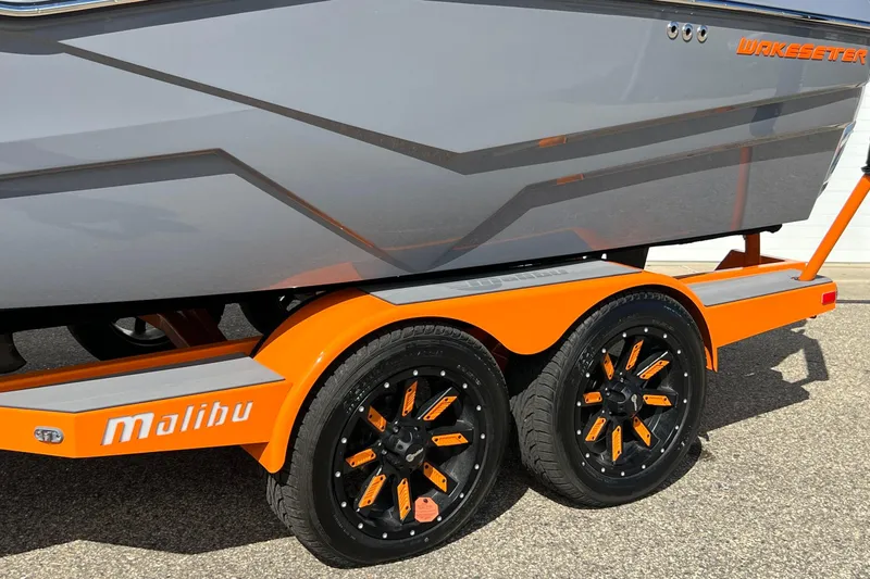 Slide: The Image of 2023 Malibu Wakesetter 22 LSV boat on orange trailer with stylish black wheels. - 35