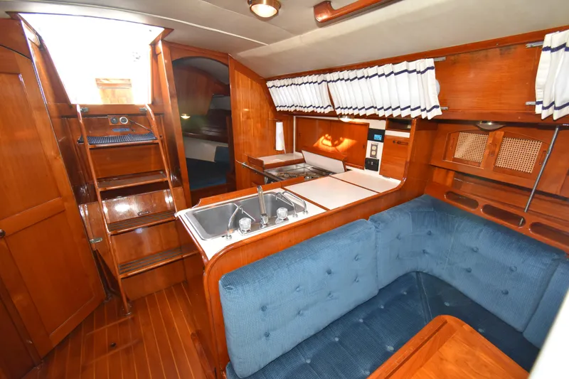 Slide: The Image of Interior of 1988 Ericson 38-200 sailboat with wooden cabinetry and blue upholstered seating. - 14