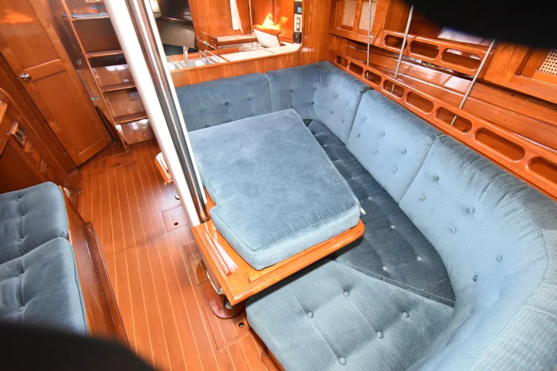 Slide: The Image of Interior of 1988 Ericson 38-200 sailboat with blue cushioned seating and wooden finishes. - 15