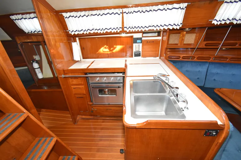 Slide: The Image of 1988 Ericson 38-200 yacht interior with wooden cabinetry, dual sink, and stove. - 16