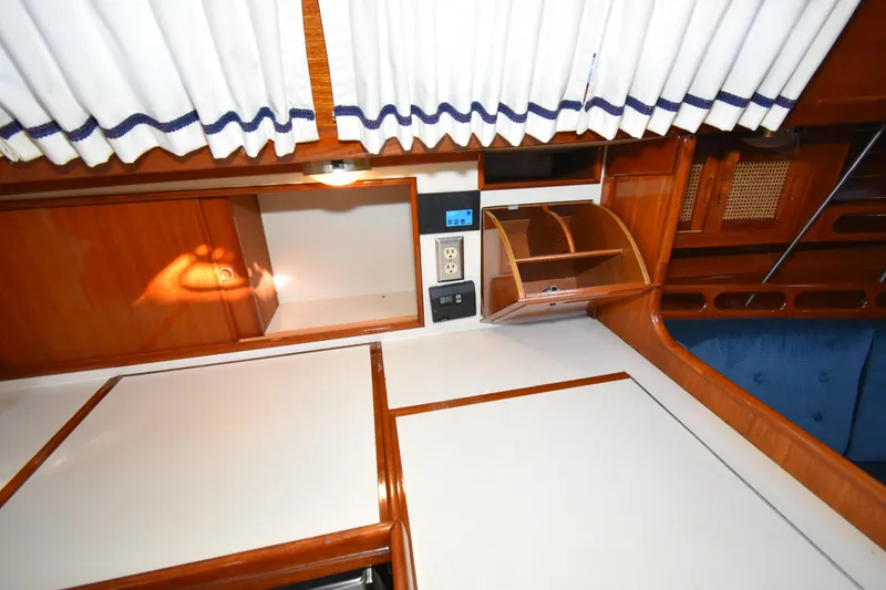 Slide: The Image of Interior of 1988 Ericson 38-200 sailboat with wood cabinetry and white countertops. - 18