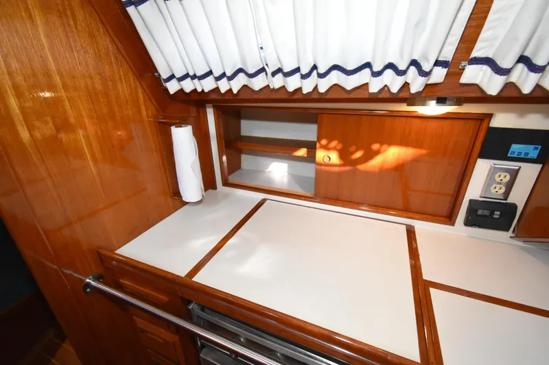 Slide: The Image of Galley of 1988 Ericson 38-200 sailboat with wood cabinetry and white countertops. - 19
