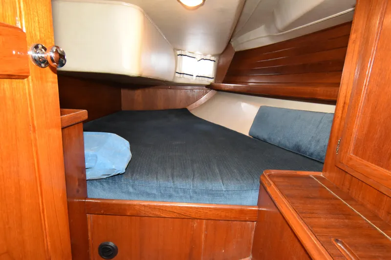 Slide: The Image of Cozy cabin interior of 1988 Ericson 38-200 sailboat with wooden finish and blue bedding. - 21