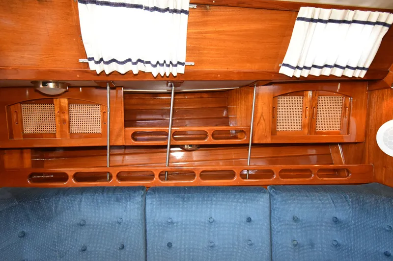 Slide: The Image of Interior of 1988 Ericson 38-200 sailboat with wooden cabinets and blue cushioned seating. - 24