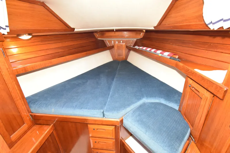 Slide: The Image of Interior cabin of 1988 Ericson 38-200 sailboat with wooden finish and blue cushions. - 28
