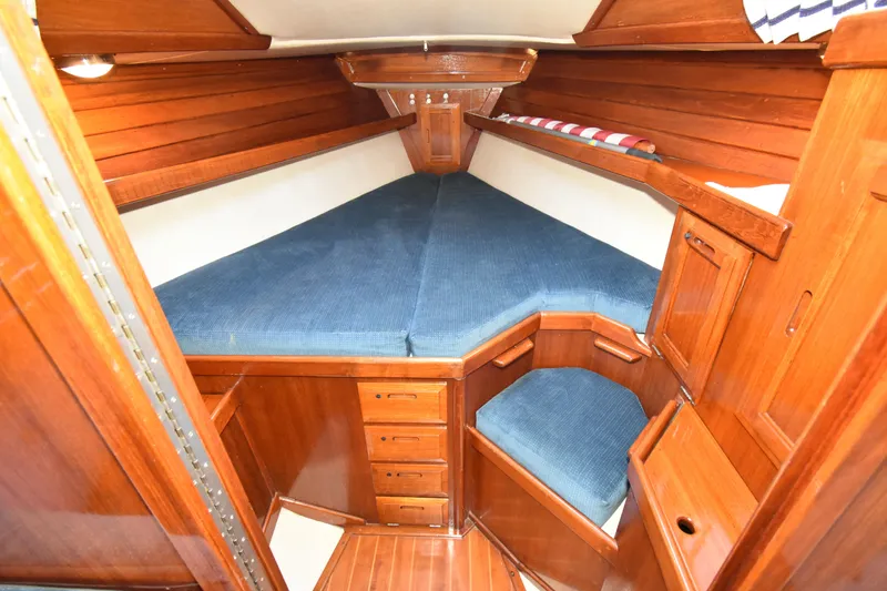 Slide: The Image of Cozy cabin interior of 1988 Ericson 38-200 sailboat with wooden finish and blue cushions. - 29