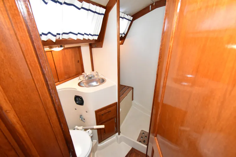Slide: The Image of 1988 Ericson 38-200 yacht bathroom with wooden cabinetry and stainless steel sink. - 33