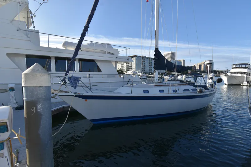 Slide: The Image of 1988 Ericson 38-200 sailboat docked in marina with cityscape background. - 41