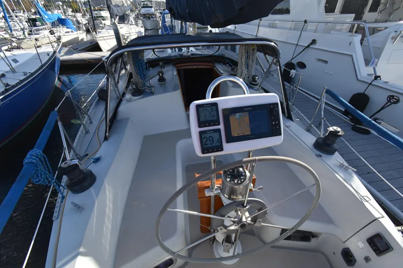 Slide: The Image of 1988 Ericson 38-200 sailboat cockpit with navigation equipment and steering wheel. - 49