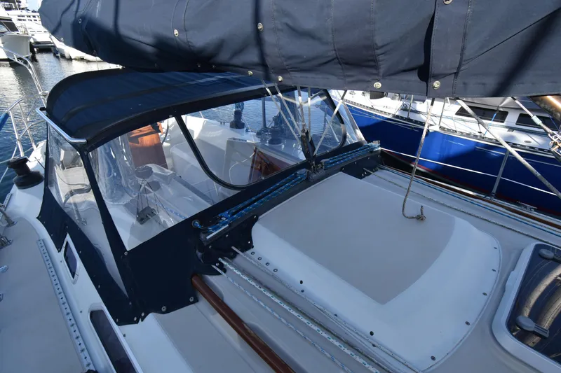 Slide: The Image of 1988 Ericson 38-200 sailboat cockpit with blue canvas cover, docked at marina. - 53