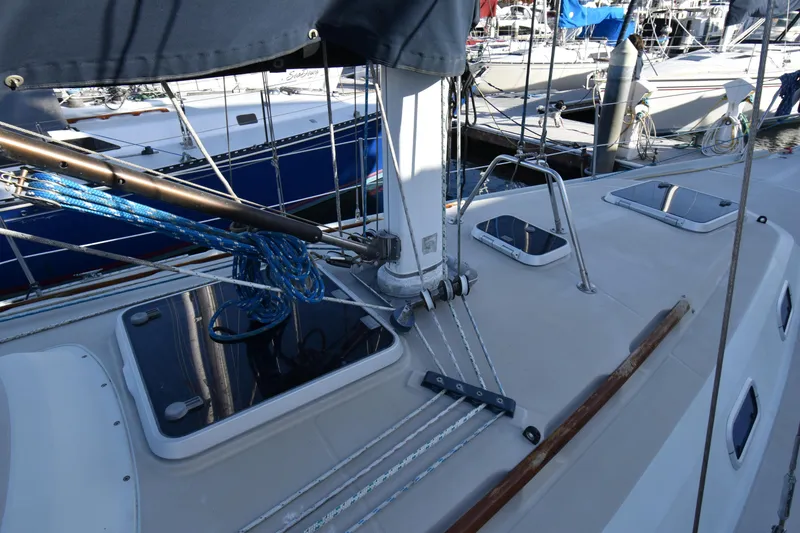 Slide: The Image of 1988 Ericson 38-200 sailboat deck with rigging and hatches in marina setting. - 54