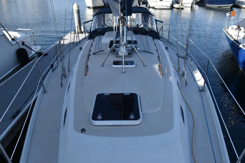 Slide: The Image of 1988 Ericson 38-200 sailboat docked at marina, showcasing deck and rigging. - 55