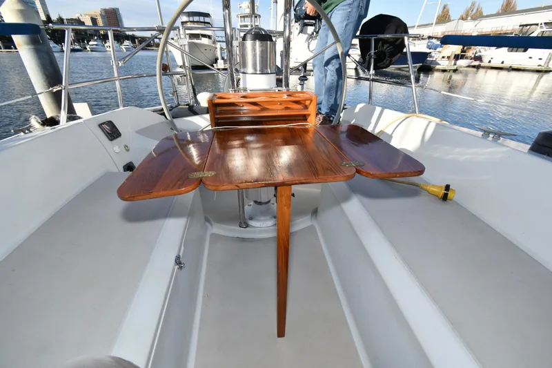 Slide: The Image of Cockpit of 1988 Ericson 38-200 sailboat with wooden folding table and steering wheel. - 62