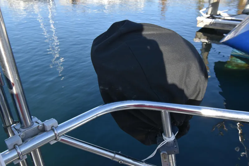 Slide: The Image of Covered outboard motor on 1988 Ericson 38-200 sailboat, docked in calm waters. - 64