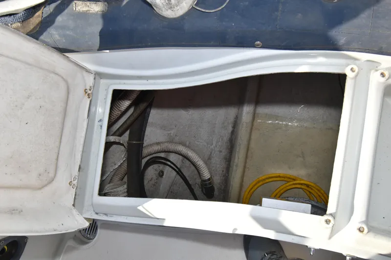 Slide: The Image of Open hatch on 1988 Ericson 38-200 sailboat, revealing storage compartment with hoses and cables. - 67