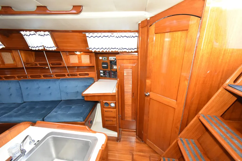 Slide: The Image of Interior of 1988 Ericson 38-200 sailboat with wooden cabinetry and blue seating. - 7