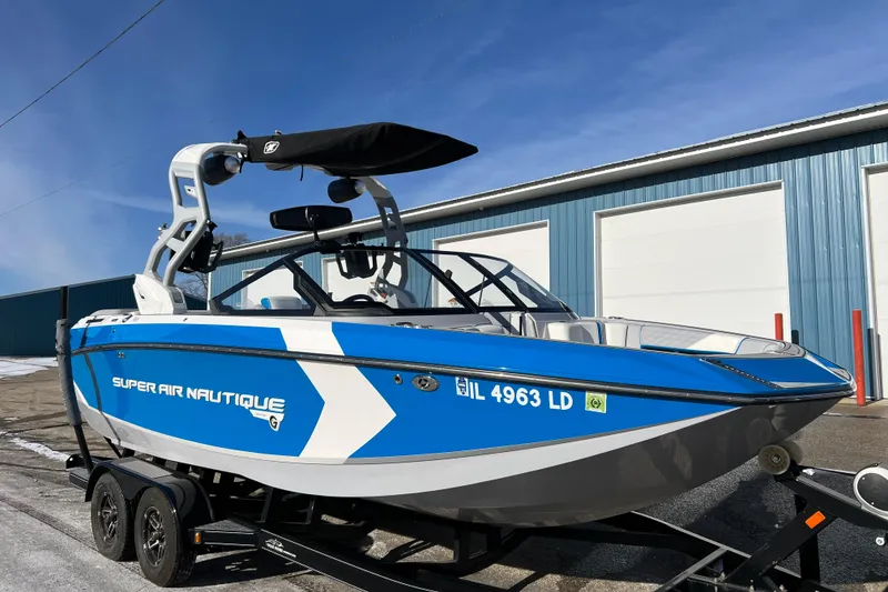 Slide: The Image of 2020 Super Air Nautique G21 boat in blue and white, parked on a trailer. - 11