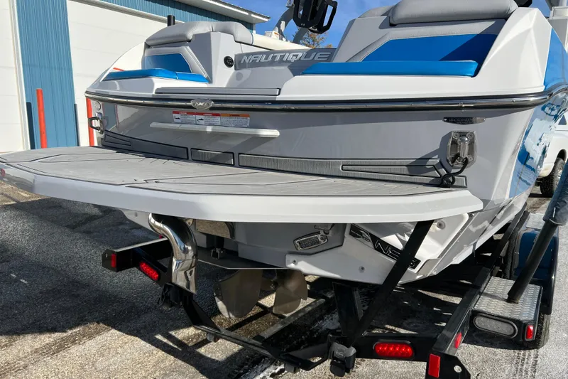 Slide: The Image of 2020 Super Air Nautique G21 boat rear view on trailer, showcasing swim platform. - 12