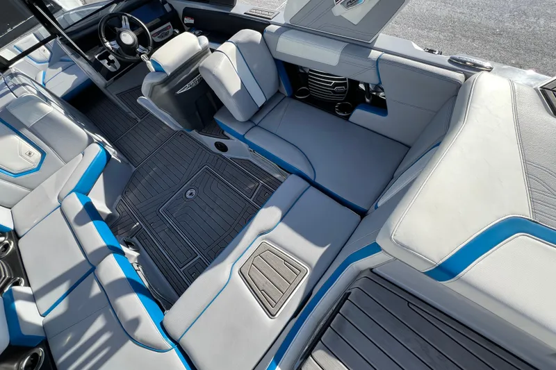 Slide: The Image of 2020 Super Air Nautique G21 interior with gray and blue seating, modern design, and steering wheel. - 17