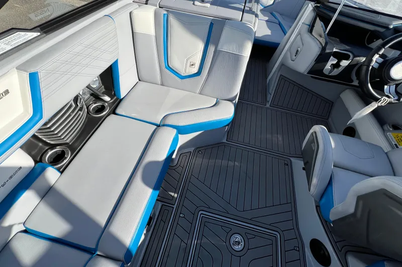Slide: The Image of 2020 Super Air Nautique G21 interior with gray and blue seating, cup holders, and sleek design. - 19