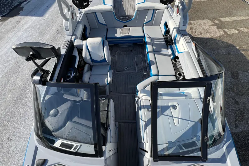 Slide: The Image of 2020 Super Air Nautique G21 boat interior with gray and blue seating, open windshield. - 29