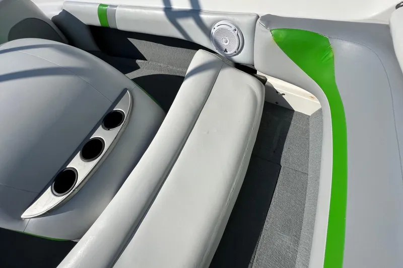Slide: The Image of 2003 MasterCraft X-5 boat interior with gray and green seating, cup holders, and speaker. - 29