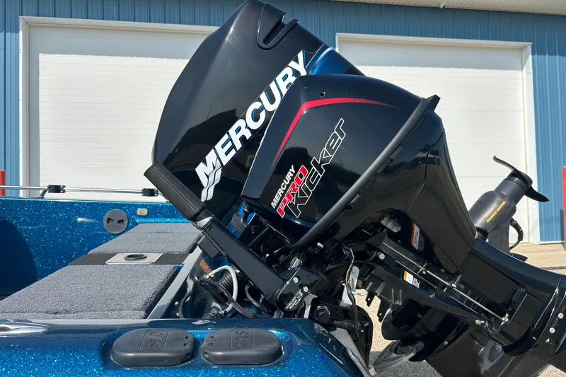 Slide: The Image of 2005 Skeeter WX1880 DC boat with Mercury engine on trailer, parked by blue building. - 29