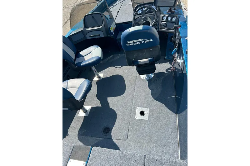 Slide: The Image of 2005 Skeeter WX1880 DC boat with Mercury Pro Kicker engine, parked near blue building. - 31