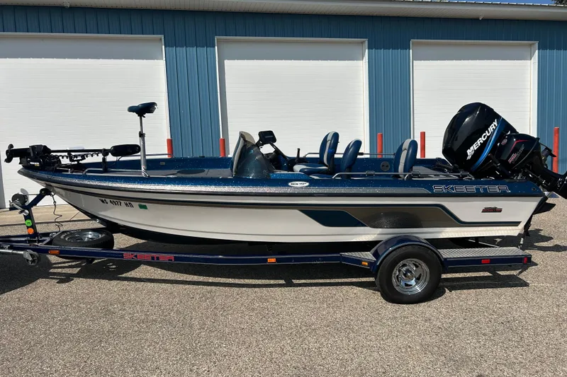 Slide: The Image of 2005 Skeeter WX1880 DC boat on trailer, parked outside blue building. - 41