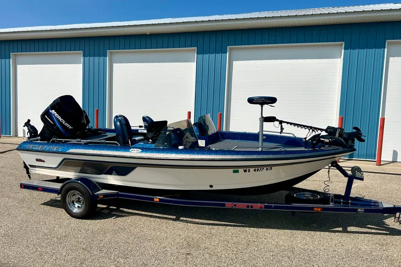 Slide: The Image of 2005 Skeeter WX1880 DC boat on trailer, parked outside blue storage units. - 5