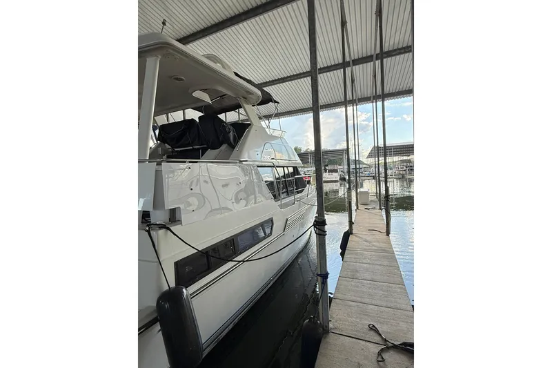 Slide: The Image of 1993 Carver 390 Cockpit Motor Yacht docked in a marina under a covered shelter. - 2