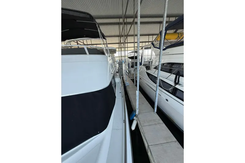 Slide: The Image of 1993 Carver 390 Cockpit Motor Yacht docked in a marina, side view. - 5