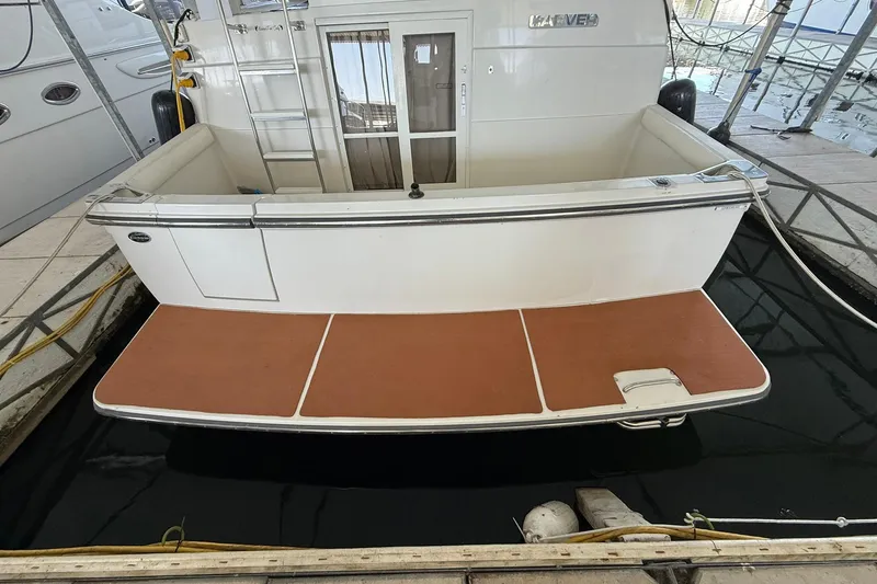 Slide: The Image of 1993 Carver 390 Cockpit Motor Yacht docked, showing rear deck and ladder. - 8