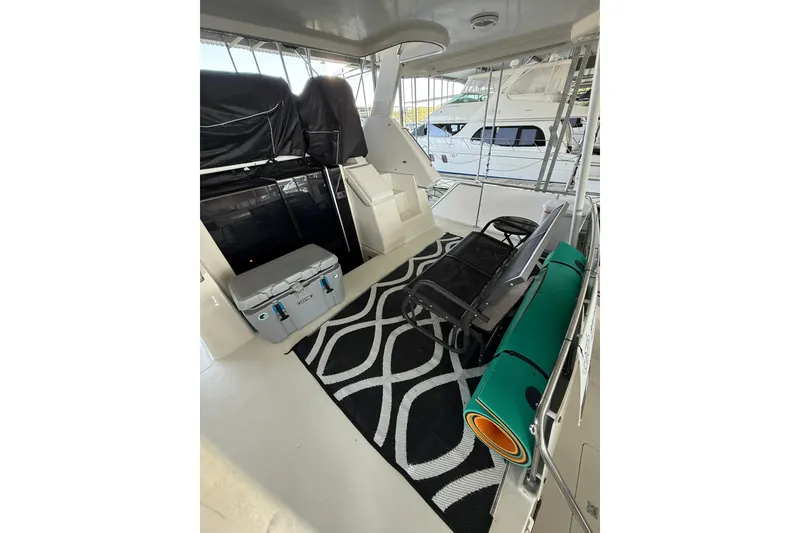 Slide: The Image of 1993 Carver 390 Cockpit Motor Yacht interior with seating, cooler, and patterned rug. - 11