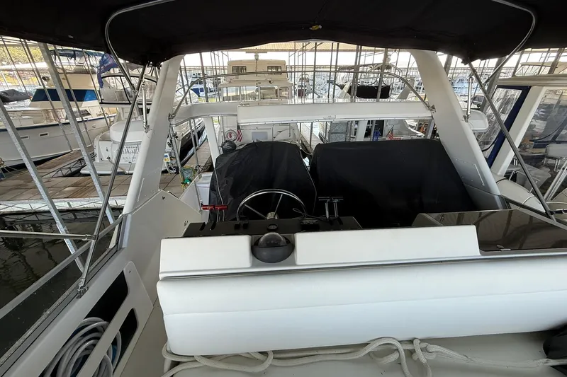 Slide: The Image of 1993 Carver 390 Cockpit Motor Yacht helm in marina setting. - 13