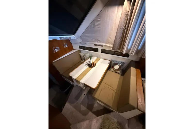 Slide: The Image of Cozy dining area in 1993 Carver 390 Cockpit Motor Yacht with table and seating. - 21