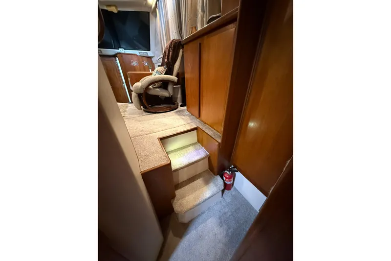 Slide: The Image of Interior of 1993 Carver 390 Cockpit Motor Yacht with carpeted steps and wooden paneling. - 23