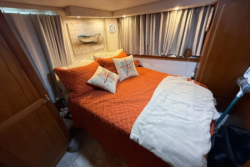 Slide: The Image of Cozy bedroom in 1993 Carver 390 Cockpit Motor Yacht with nautical decor and starfish pillows. - 27