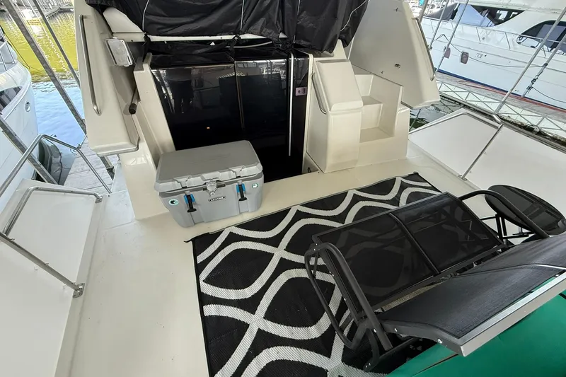 Slide: The Image of 1993 Carver 390 Cockpit Motor Yacht interior with seating, cooler, and patterned rug. - 9
