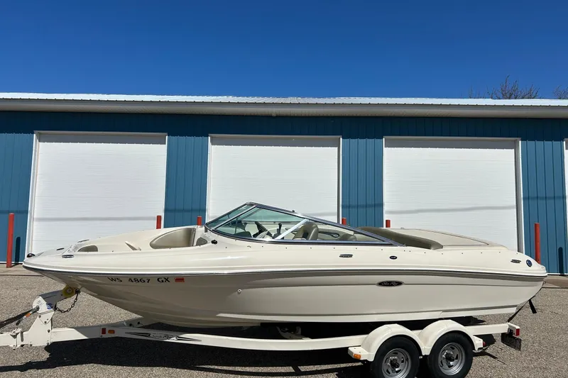 Slide: The Image of 2005 Sea Ray 200 Sport boat on trailer, parked in front of blue building. - 10